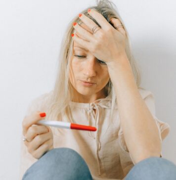 Jak stres w ciąży wpływa na rozwój mózgu dziecka i które obawy przyszłej mamy są przesadzone według badań Zaniepokojona kobieta trzyma pozytywny test ciążowy w dłoni